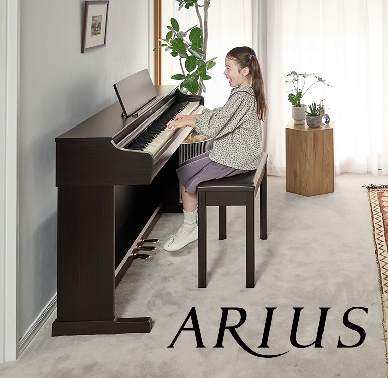 Uma menina tocando um piano digital ARIUS em casa, demonstrando uma musicalidade em constante crescimento e uma expressão emocional mais profunda.
