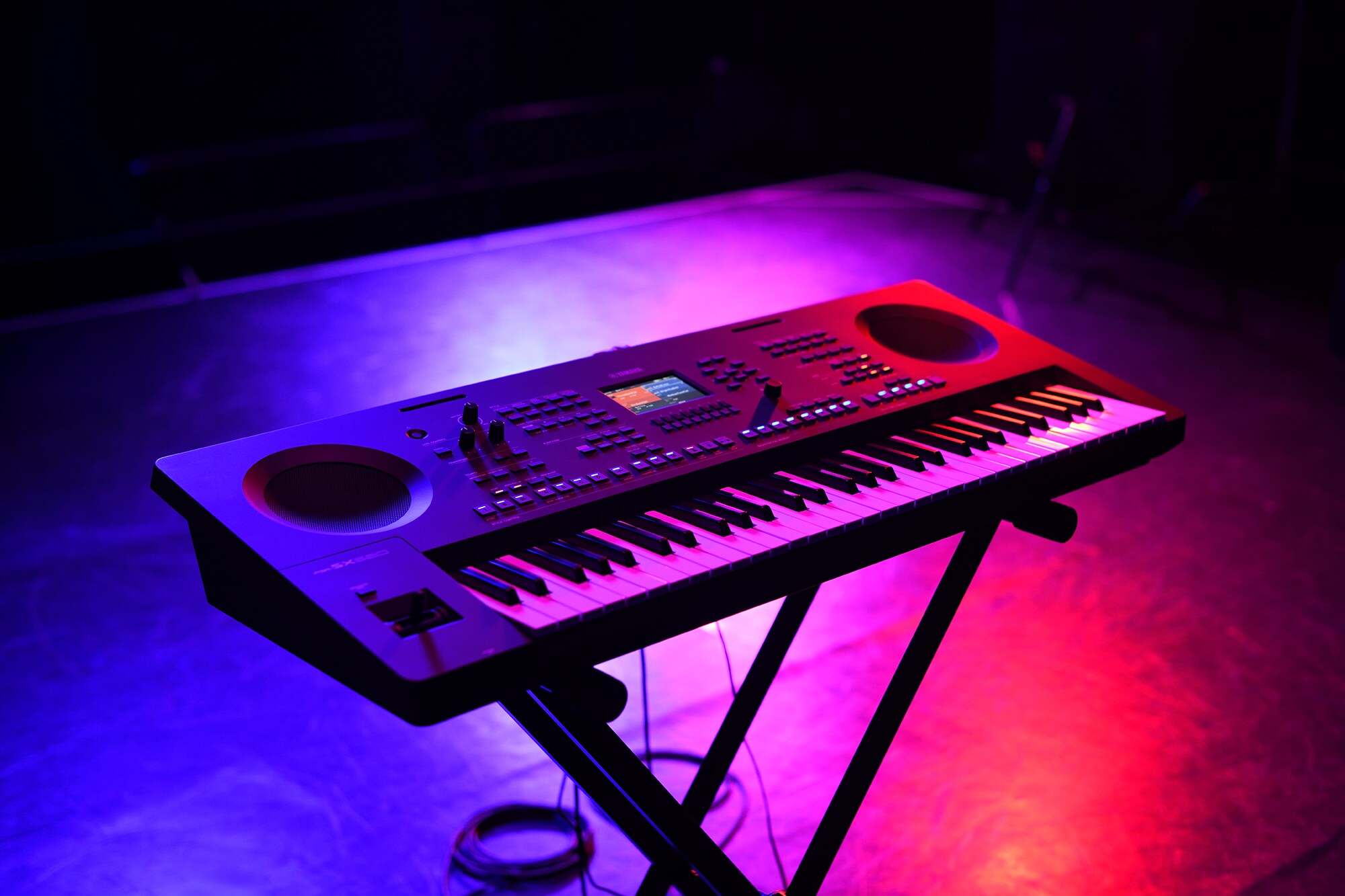 Um teclado em um suporte sob iluminação de palco