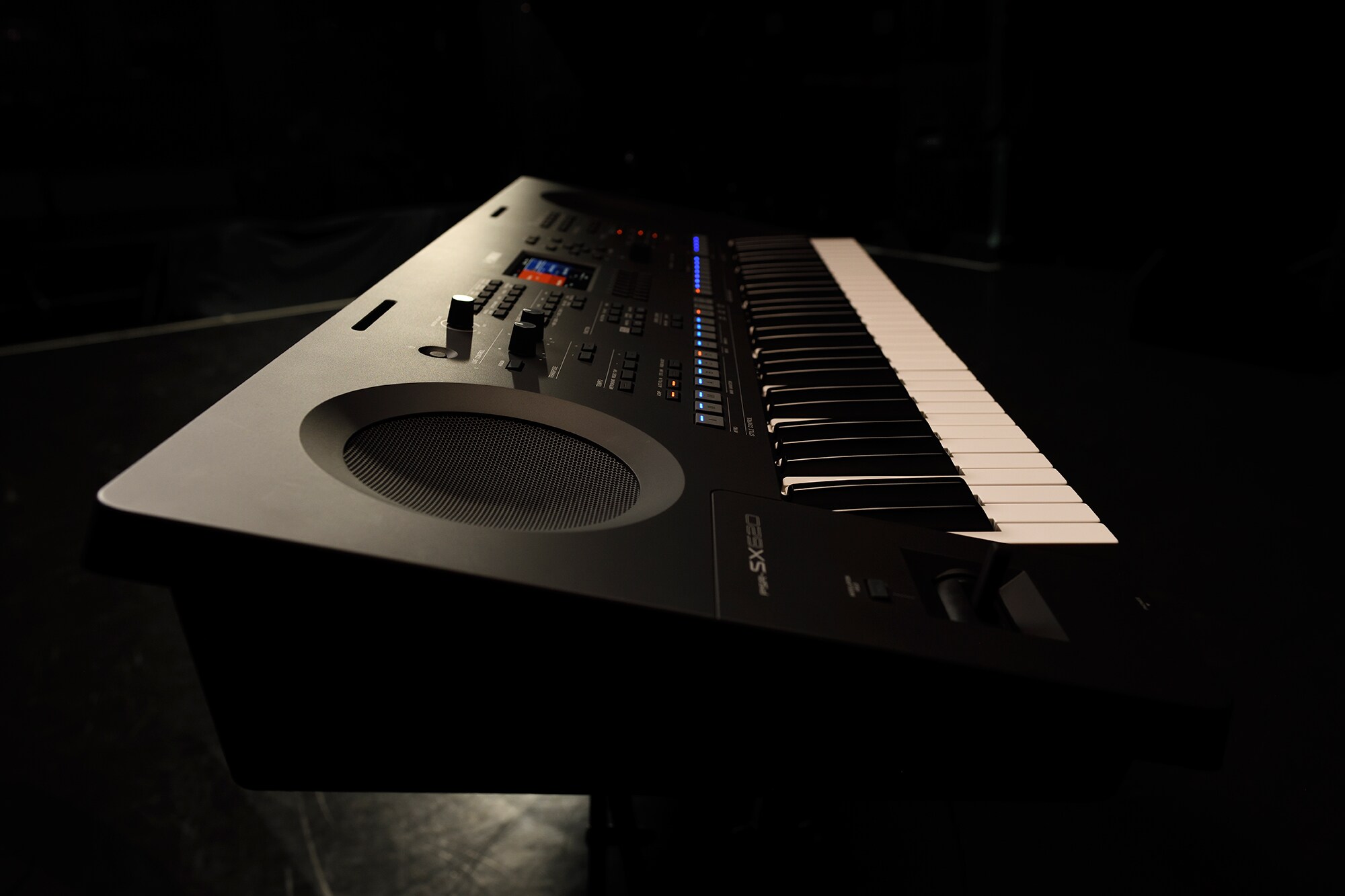 Um teclado em um suporte sob iluminação de palco