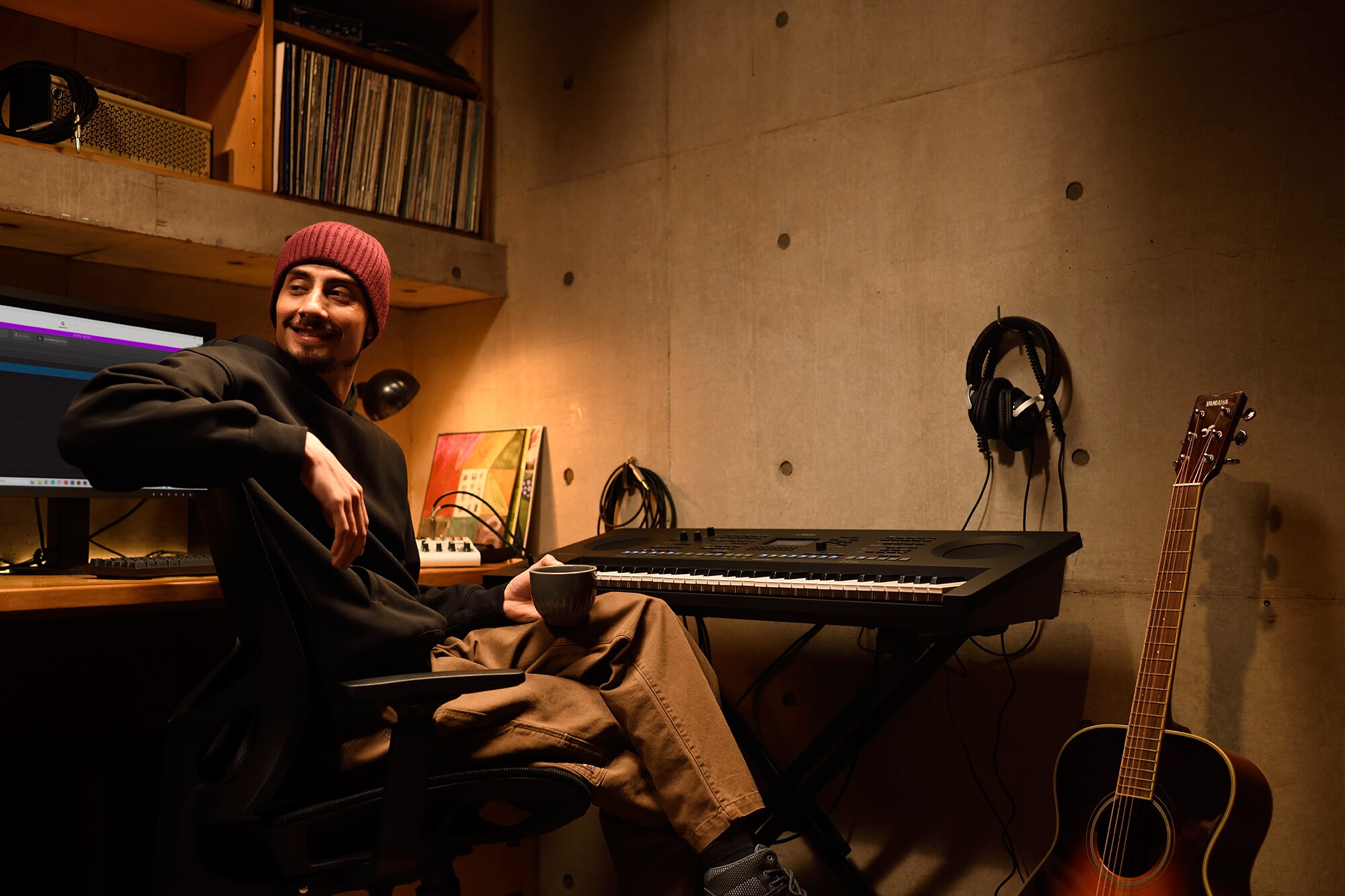 Um espaço de trabalho musical em casa com um computador e um teclado, apresentando um tecladista trabalhando em seu home studio