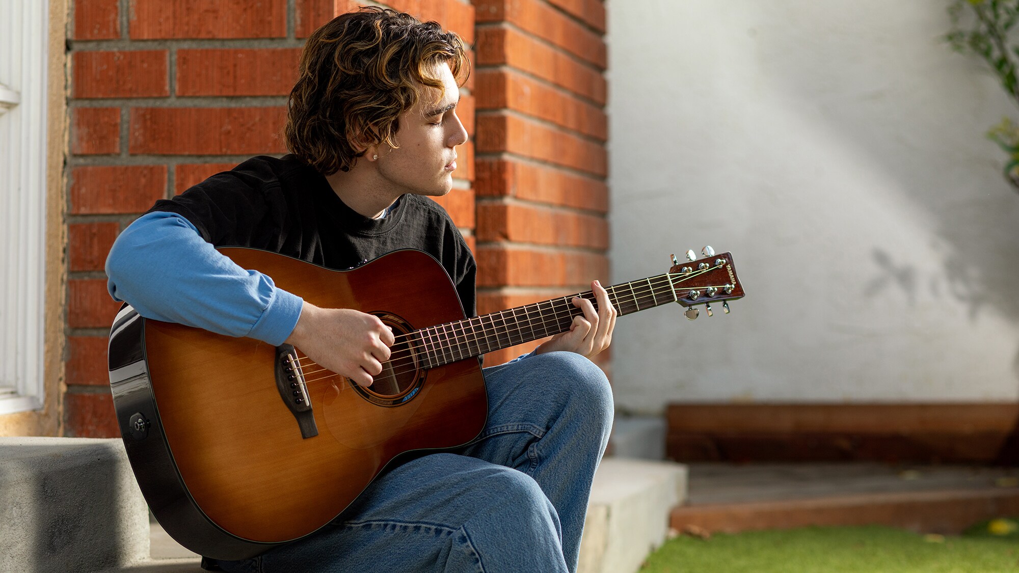 Um homem tocando um violão TAG1 E ao ar livre