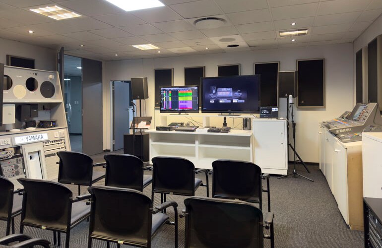 Centro de treinamento de Joanesburgo, com assentos, caixas acústicas Yamaha, telas e equipamentos de áudio.