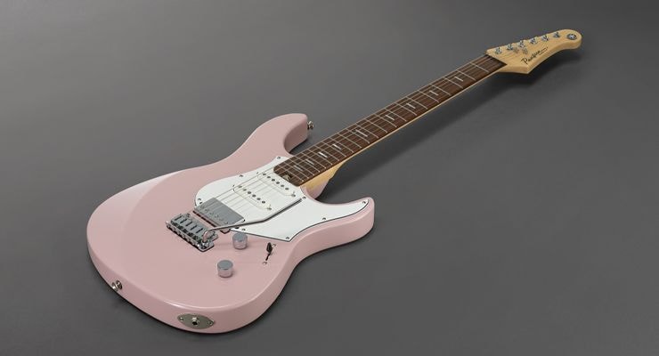 Ash Pink Pacifica Standard Plus with rosewood fingerboard laying on ground.