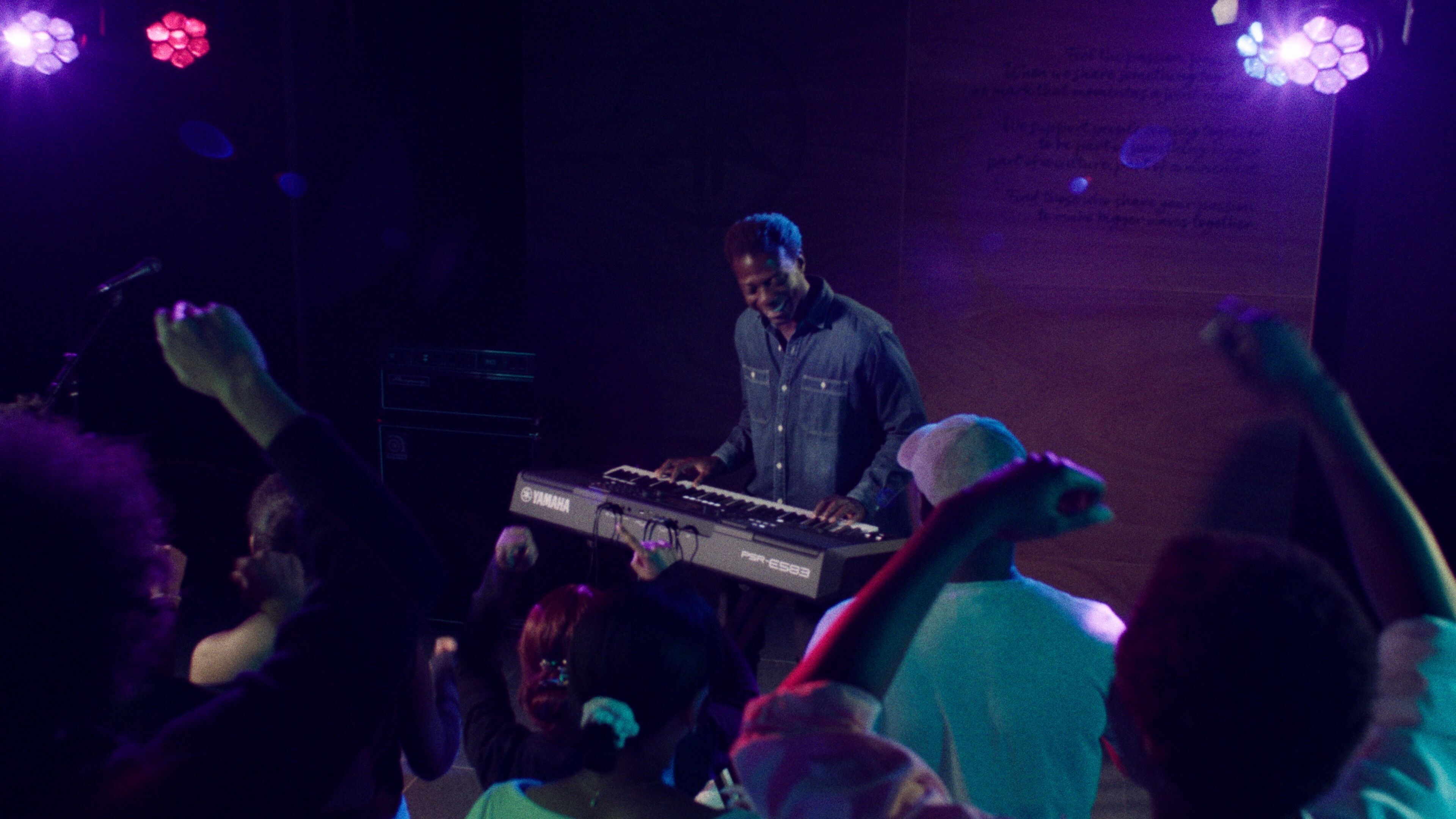 Uma pessoa tocando o Teclado Portátil Yamaha PSR-E583 com fones de ouvido