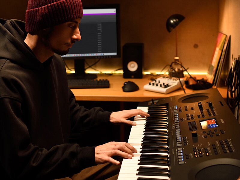 Pessoa tocando no teclado PSR-SX620 em um home studio.