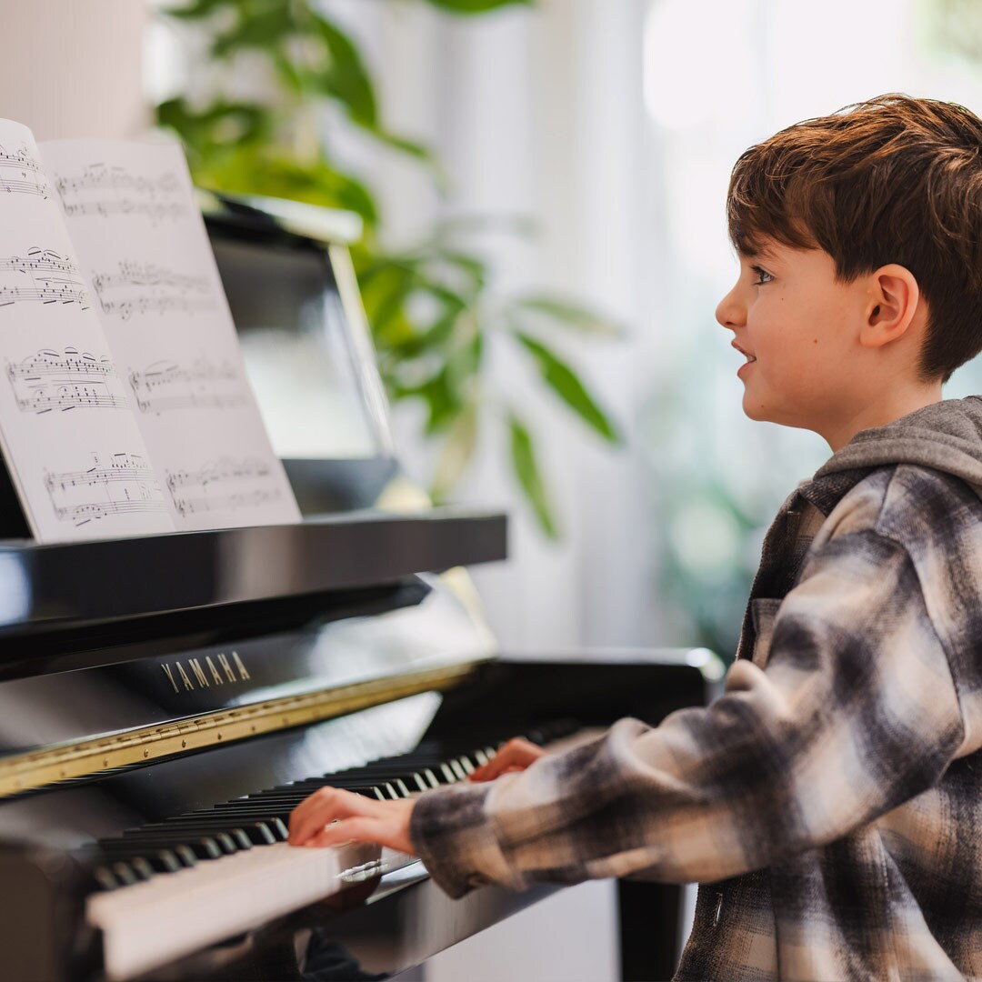 Uma mulher se diverte tocando o piano vertical da B Series