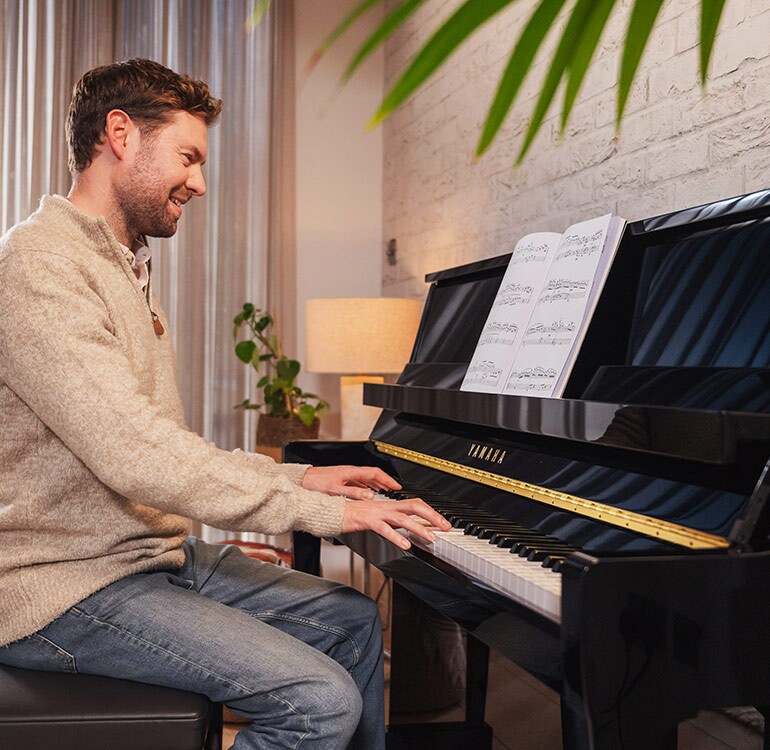 Uma mulher se diverte tocando o piano vertical da B Series