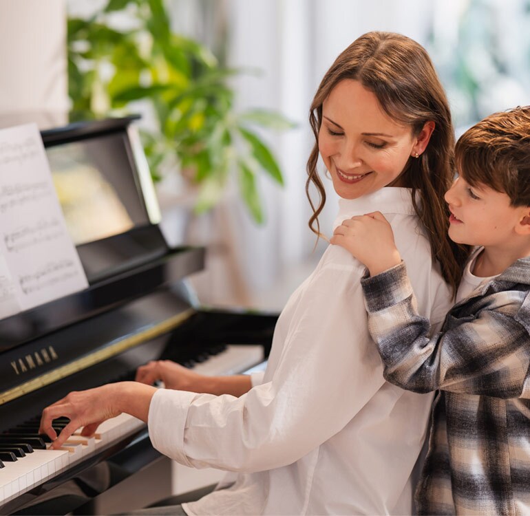 Mãe e filha se divertem tocando o piano vertical da B Series