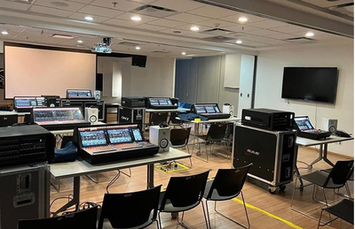 Centro de treinamento da Cidade do México, com consoles de mixagem digital, telas e assentos na sala de treinamento.
