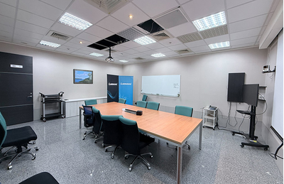 Centro de treinamento da Cidade de Hsinchu, com mesa de reunião, tela de exibição e equipamentos de apresentação.