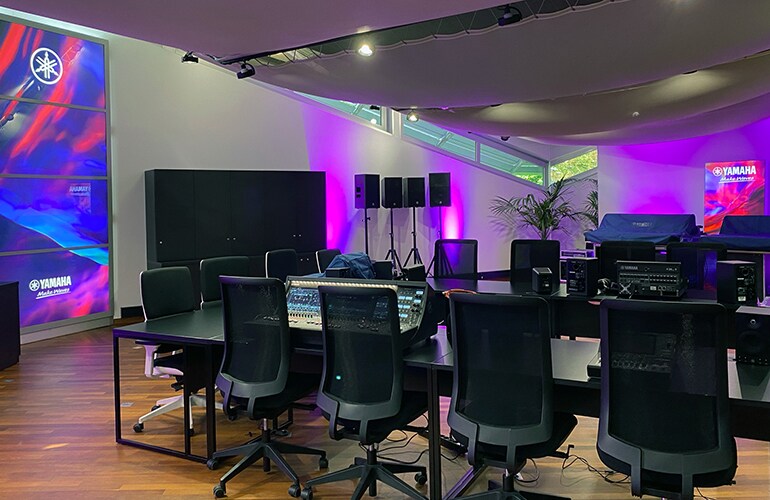 Centro de treinamento de Croissy-Beaubourg, com equipamentos de áudio Yamaha, tela de exibição e iluminação roxa.