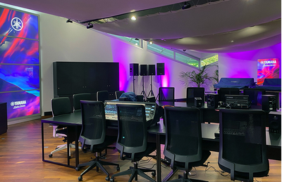 Centro de treinamento de Croissy-Beaubourg, com equipamentos de áudio Yamaha, tela de exibição e iluminação roxa.