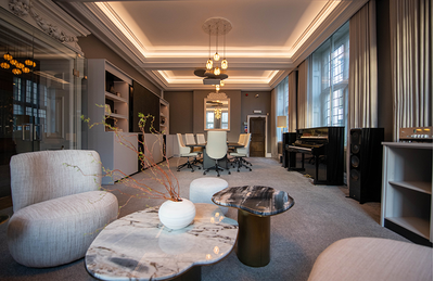 Sala em estilo lounge do centro de treinamento de Londres, com assentos e área de apresentação.