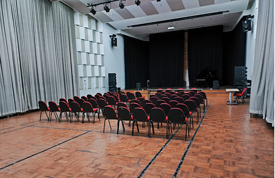 Auditório do centro de treinamento de Jacarta, com palco, tela de projeção e assentos.