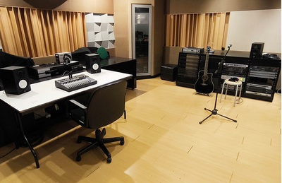 Sala do centro de treinamento de Jacarta, com mesas, assentos e equipamentos de treinamento de áudio.