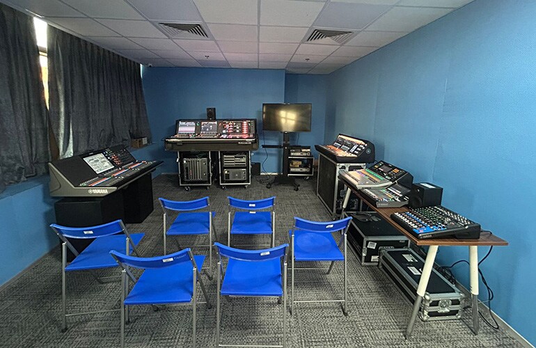 Centro de treinamento de Gurugram, com assentos em formato sala de aula, tela de apresentação e equipamentos de treinamento de áudio.
