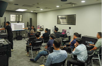 Centro de treinamento da Cidade de Ho Chi Minh, com participantes sentados durante uma sessão de treinamento de áudio.