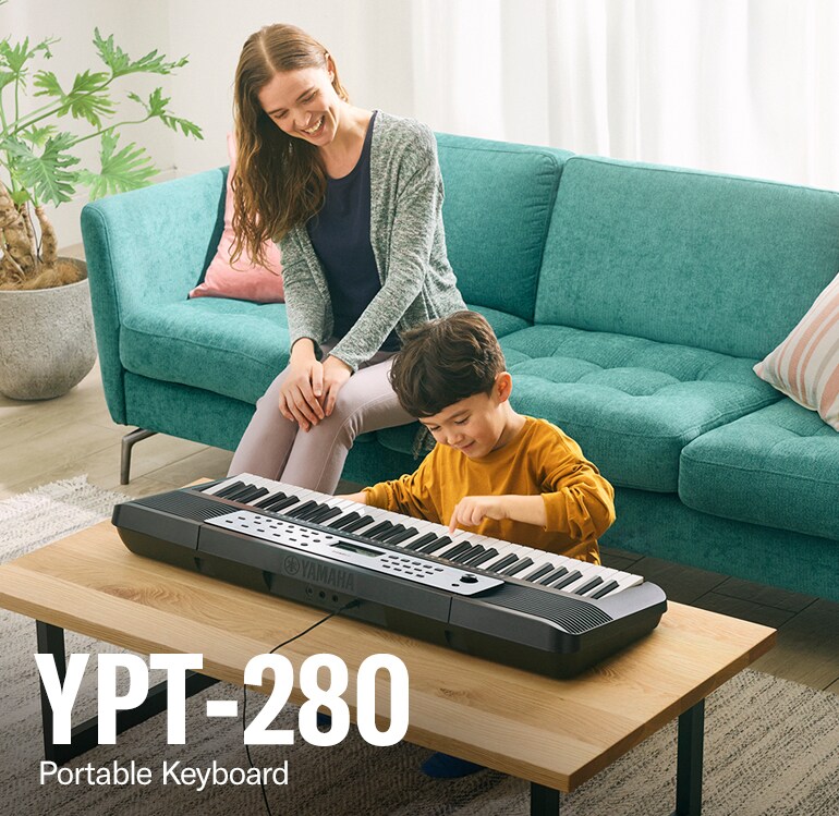 Parent and child happily playing the YPT-280 on the table
