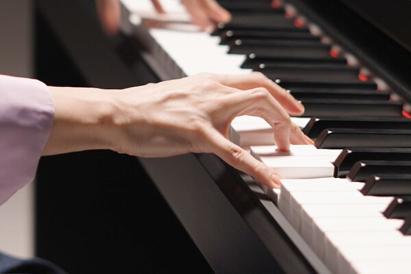 Mãos tocando o teclado Graded Hammer Standard (GHS)
